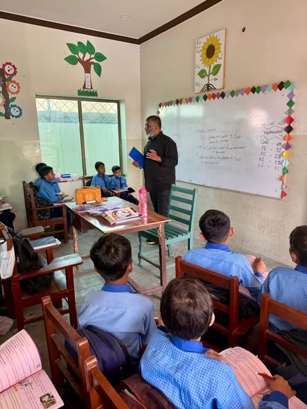 A teacher working with students at Grace Charity School